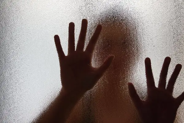 child behind frosted glass